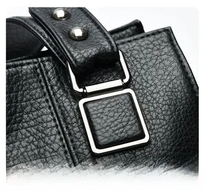 Gros plan sur la boucle carrée argentée et le rivet renforcé du sac à main en cuir noir