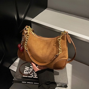 Retro brown suede underarm bag with cherry pendant and chain strap on urban books