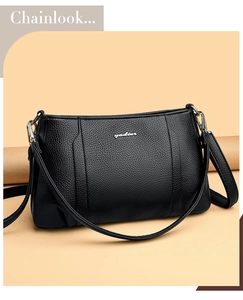 Close-up of black lychee grain leather shoulder bag with silver yadier metal logo