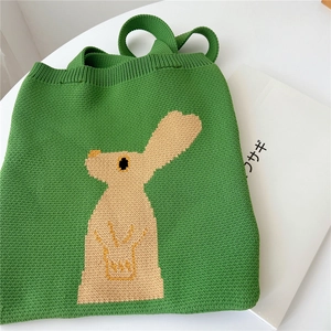 Green knitted tote bag with cream bunny pattern and yellow crown detail for women