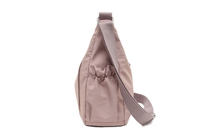 Detail view of pink Oxford fabric crossbody bag featuring elastic side pockets and strap