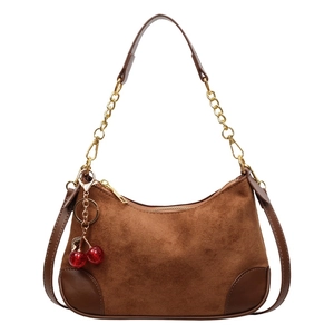 Brown suede underarm bag with gold chain strap and decorative red cherry pendant