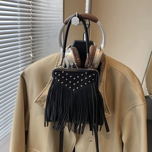 Detail of black suede fringe handbag with silver kiss lock and stylish metal rivets