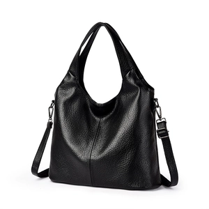 Minimalist black pebbled leather tote bag with top handle and adjustable shoulder strap