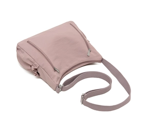Detail of mauve nylon crossbody bag with dual zipper compartments and pleated side pockets