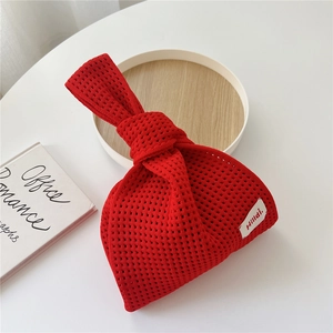 Detail einer roten Stricktasche mit Knotengriff und minimalistischem Hilldi-Markenetikett
