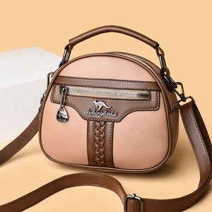 Pink semi-round crossbody bag with brown trim and kangaroo logo on geometric blocks