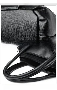 Détail de la texture du cuir grainé et des coutures précises sur la poignée du sac à main