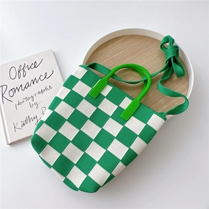 Detailed knit texture of green checkerboard tote with rigid handle and strap