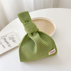 Nahaufnahme der grünen Stricktasche mit Markenetikett und gewebter Mesh-Textur-Optik