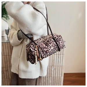 Detail of leopard print cylinder shoulder bag with leather strap and tassel charm
