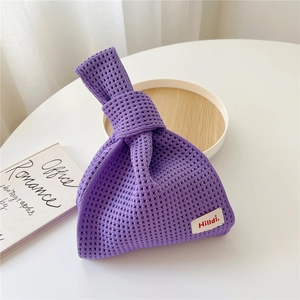 Detail der lila Stricktasche mit durchbrochenem Muster und minimalistischem Markenetikett