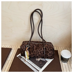 Detail of retro leopard print cylinder bag with colorful beaded charm and slim straps