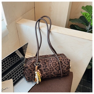 Detail of retro leopard print barrel bag with wooden beaded tassel and leather handles