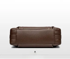 Detailed view of the brown pebbled leather handbag base showing reinforced stitching
