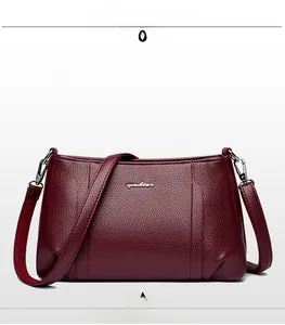 Detailed front view of the purple pebbled leather crossbody bag with silver logo detail