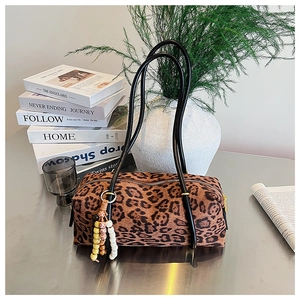 Close-up of leopard print Boston bag with black handles and beaded tassel detail
