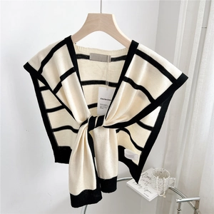 Detailed close-up of striped knit shawl draped on a hanger showing premium texture