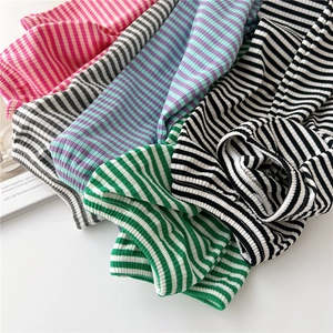 Macro view of multi-color striped knitted arm sleeves with elastic ribbed texture