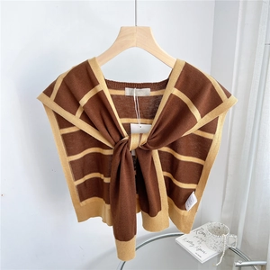 Close-up of striped knit shawl with brown and ginger patterns and tie-up neckline