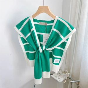 Detail of green and white striped knit shawl featuring elegant ribbed edges and soft texture