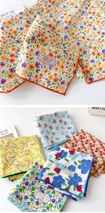 Détail de foulards en coton fleuri montrant la texture respirante et les bords