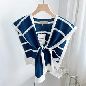 Close-up of blue and white striped knitted shawl with a decorative front tie knot