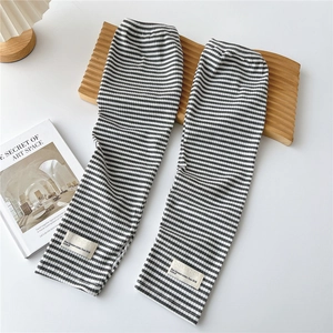 Close-up of black and white striped knitted arm sleeves with vintage style fabric label