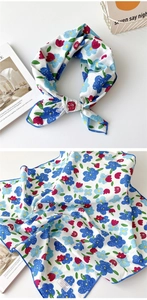 Détails d'un foulard carré en pur coton à imprimé floral et couture bleue soignée