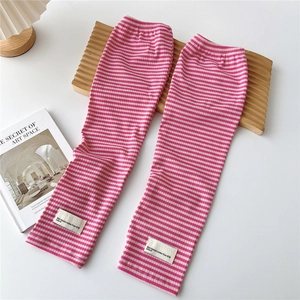 Close-up of pink and white striped knit arm sleeves with rib cuffs and woven label