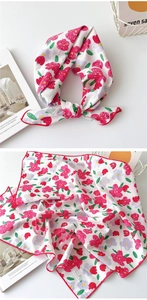 Détail du foulard floral en coton montrant l'étiquette 100% coton et l'ourlet rouge