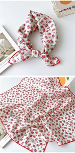 Détail du motif floral rouge sur foulard carré en coton crème avec surpiqûres délicates