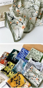Macro detail of lightweight sheer floral scarves with elegant rolled edge stitching