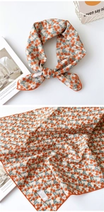 Détail d'un foulard carré en coton à motif floral avec ourlet orange et style frais