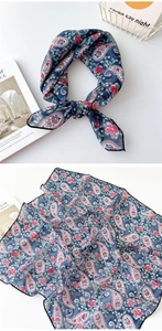 Detail eines dunkelblauen Paisley-Seidentuchs mit Blumenmuster und schwarzem Saum