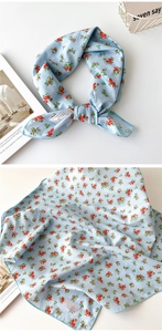 Détail d'un foulard en coton bleu clair à fleurs rouges avec coutures fines