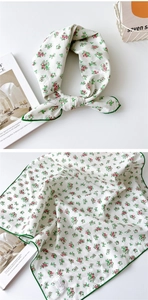 Gros plan d'un foulard en coton à fleurs montrant l'étiquette 100% coton et les coutures vertes