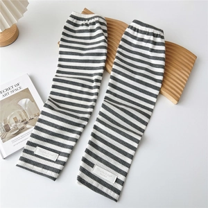 Detail of grey and white striped knit sleeves on a decorative wooden tray