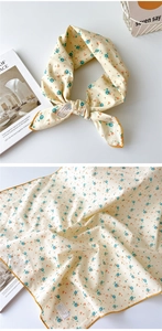 Détail macro du foulard en coton fleuri montrant la texture coton et la couture jaune moutarde