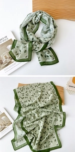 Detail of green floral chiffon scarf showing lightweight texture and daisy leaf print