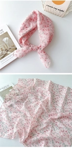 Detailansicht eines rosa Chiffon-Halstuchs mit elegantem rotem Blumendruck und Struktur
