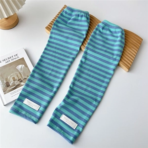 Detail of blue striped knitted arm sleeves with white woven label on ribbed fabric