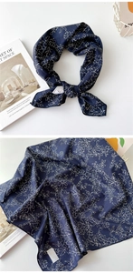 Détail d'un foulard en coton bleu foncé à motifs floraux blancs et effet plissé
