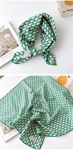 Détail du foulard en coton avec motif géométrique vert et bords finement surpiqués