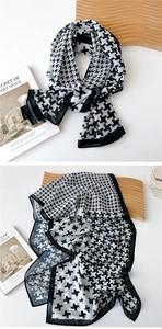 Detail of thin houndstooth chiffon scarf with fine black stitched edges on art book
