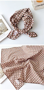 Gros plan du foulard en coton à motifs géométriques montrant l'étiquette 100% coton