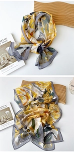 Close-up of lightweight chiffon scarf with abstract watercolor prints and rolled edges