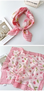 Detail eines rosa Baumwoll-Leinen-Schals mit Kirschmuster und klassischem Karorand