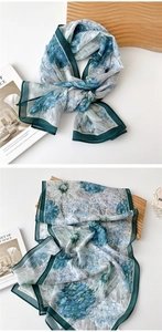 Detail of dark green border and blue floral print on sheer lightweight long silk scarf