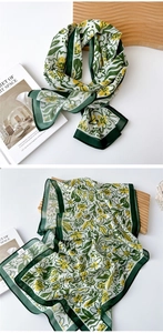 Detail of thin floral chiffon scarf showing delicate yellow-green print and silk texture